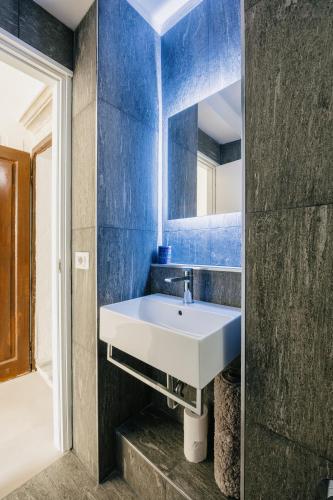 a bathroom with a white sink and a blue wall at Studio d'Art - Centro Storico di Arezzo in Arezzo