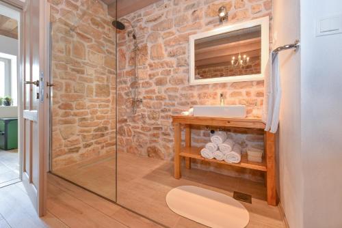 a bathroom with a sink and a glass shower at Rural House Kod Slapa in Bogatić