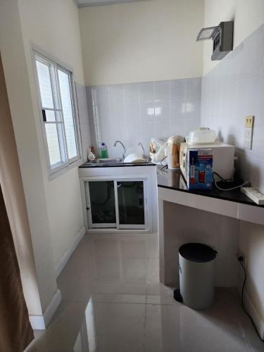 a small kitchen with a counter and a sink at Pleun City Village in Pran Buri