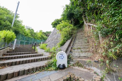 a stairs with a sign with an arrow on it at 東京駅まで30分 日本の囲炉裏 1棟貸切 16名 130平米 2バスルーム パノラマビュー 桜 富士山 in Ichikawa