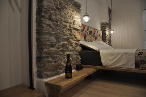 a bedroom with a bed and a bottle of wine at B&B la cruna deLago in Omegna