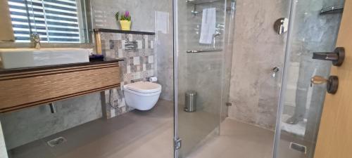 a bathroom with a shower and a toilet and a sink at Montecarlo Hotel in Mahabalipuram
