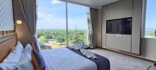 a bedroom with a bed and a large window at Montecarlo Hotel in Mahabalipuram