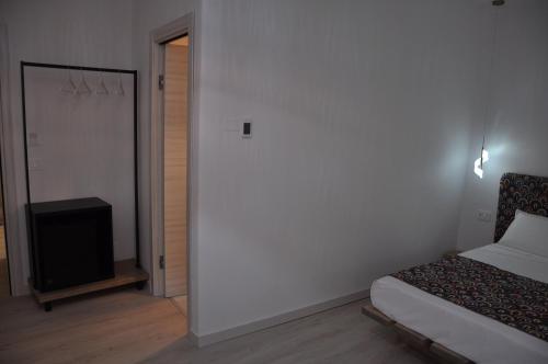 a bedroom with a bed and a flat screen tv at B&B la cruna deLago in Omegna