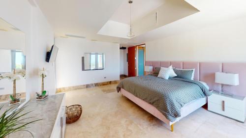 a bedroom with a bed and a table at Villa Porto Fino,Modern Mansion, Pool, Jacuzzi, Basketball Court in Rio Grande