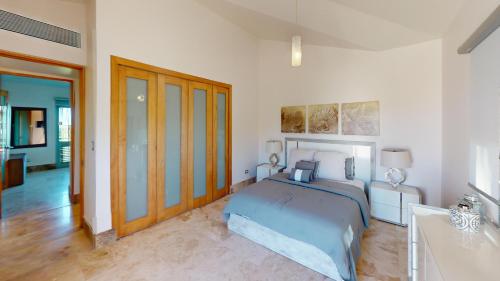a bedroom with a blue bed and a bathroom at Villa Porto Fino,Modern Mansion, Pool, Jacuzzi, Basketball Court in Rio Grande