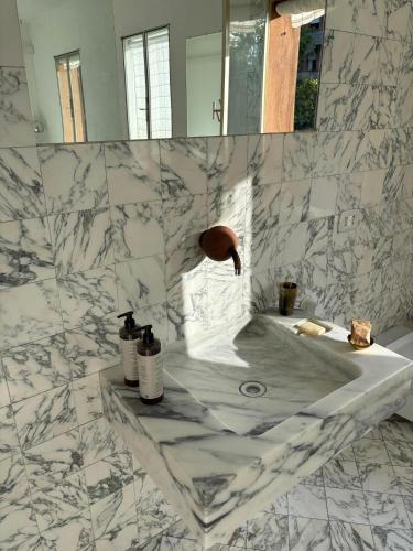 a white marble bathroom with a sink and a mirror at Arazzo Apartments in Modena