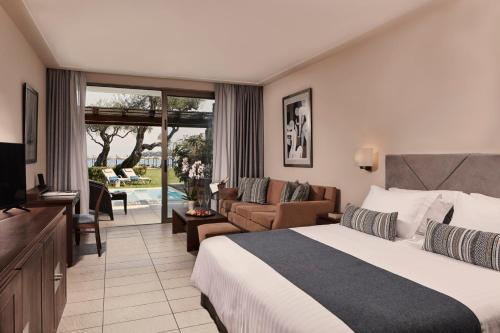 a hotel room with a bed and a living room at Kontokali Bay Resort & Spa in Kontokali