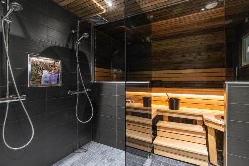 bagno con doccia e parete in legno di Villa Borealis Levi a Levi