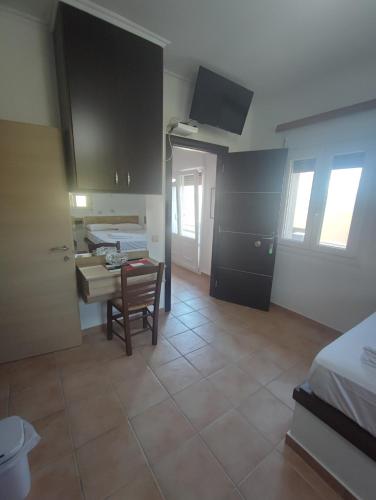 a room with a kitchen and a table and a room with a bed at Porto Mesta Residence in Liménas