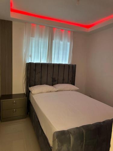 a bedroom with a bed with a red light above it at Bienvenido a tu refugio de lujo in Santo Domingo
