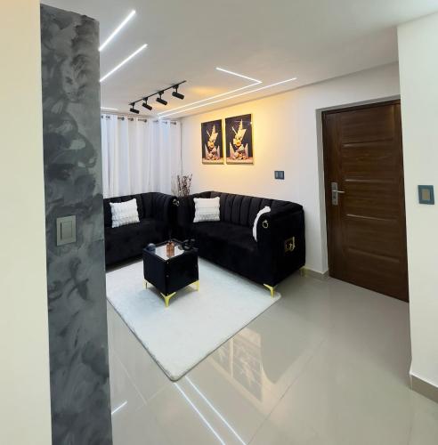 a living room with a black couch and a table at Bienvenido a tu refugio de lujo in Santo Domingo