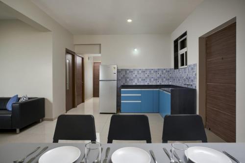 a kitchen with a table and chairs and a refrigerator at Paprika Stays Panjim Donapaula in Panaji