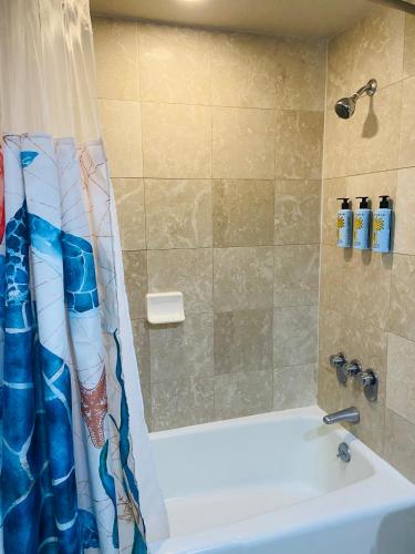 a bathroom with a shower curtain and a tub at Luana Waikiki hotel& suites in Honolulu