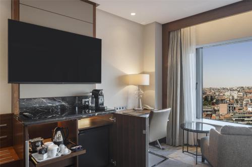 a hotel room with a large flat screen tv at Conrad Istanbul Bosphorus in Istanbul