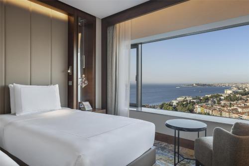 a hotel room with a bed and a large window at Conrad Istanbul Bosphorus in Istanbul
