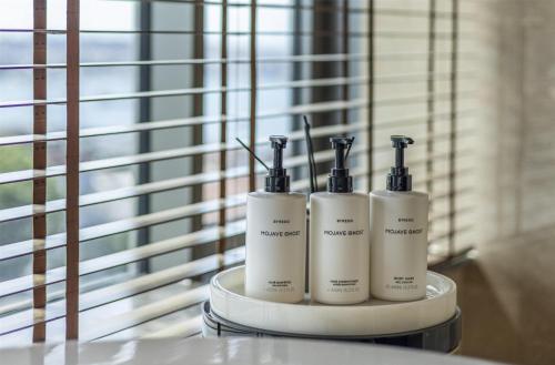 a group of three soap dispensers sitting on a table at Conrad Istanbul Bosphorus in Istanbul