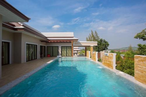 a swimming pool in the backyard of a house at บ้านครีมครูเมย์ พูลวิลล่า in Ban Nong Ban Kao