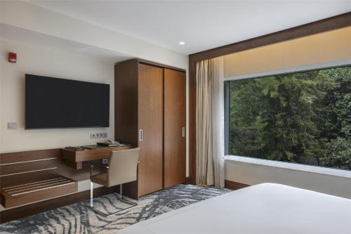 a bedroom with a desk and a large window at Conrad Istanbul Bosphorus in Istanbul