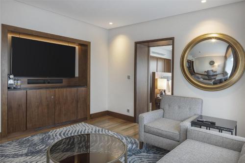 a living room with a couch and a tv at Conrad Istanbul Bosphorus in Istanbul
