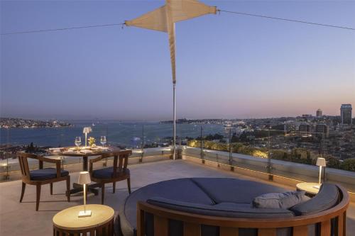 a balcony with a table and a view of the city at Conrad Istanbul Bosphorus in Istanbul