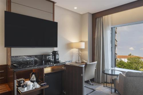 a hotel room with a large flat screen tv on the wall at Conrad Istanbul Bosphorus in Istanbul