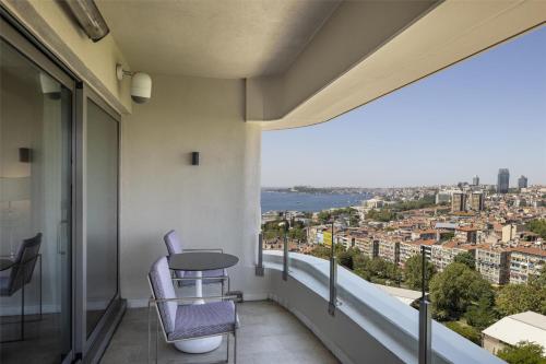 a balcony with a table and a view of the city at Conrad Istanbul Bosphorus in Istanbul