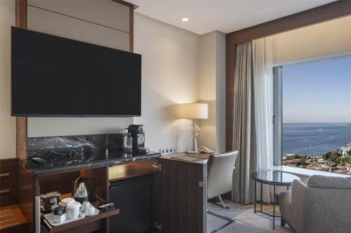 a hotel room with a large flat screen tv at Conrad Istanbul Bosphorus in Istanbul