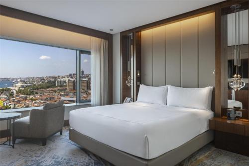 a bedroom with a large white bed and a window at Conrad Istanbul Bosphorus in Istanbul