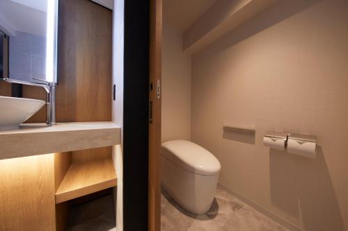 a bathroom with a toilet and a sink at Hotel Stelle Belle in Hakuba