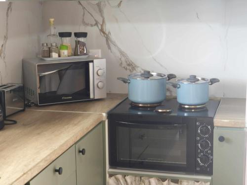 a kitchen with two pots on top of a microwave at RAVANIS Home in Áyios Pétros