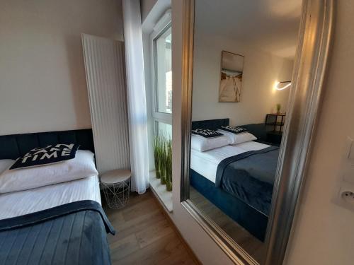 uno specchio in una stanza con due letti e una finestra di Apartamenty Idea Centrum Studio z miejscem parkingowym a Radom