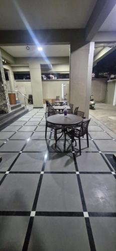 a room with tables and chairs on a tiled floor at Sunrise Service Apartment in Dāpuri