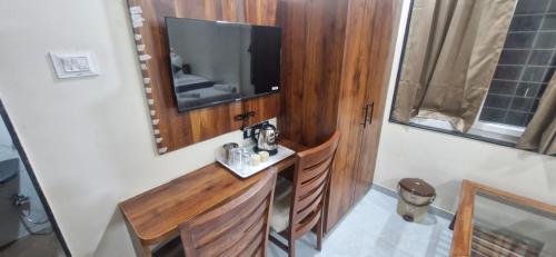 a room with a table and a television on a wall at Sunrise Service Apartment in Dāpuri