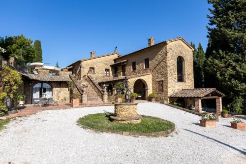 a large stone house with a fountain in the yard at Podere del Botruccio in Pomarance