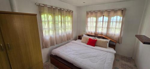 a bedroom with a bed with white sheets and red pillows at House 2 Bedroom with Seaviews near Haad Rin in Koh Phangan