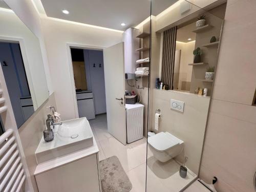 a white bathroom with a toilet and a sink at Primosten Resort Sunhill Deluxe Apartment Laura in Primošten