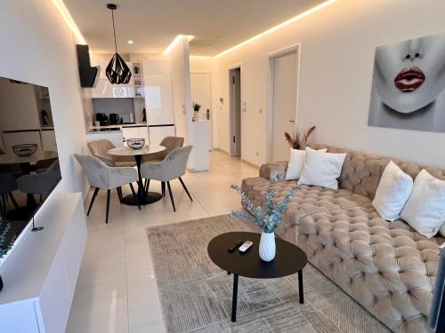 a living room with a couch and a table at Primosten Resort Sunhill Deluxe Apartment Laura in Primošten