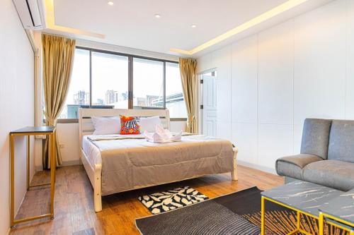 Un dormitorio con una cama, un sofá y una silla. en Pattaya Sea View Apartment, en Pattaya South
