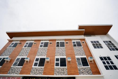 een hoog gebouw met stoelen ervoor bij MGM tourist Inn in Tagbilaran-stad