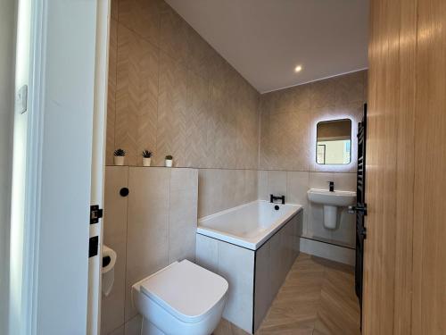 a bathroom with a toilet and a sink at Modern 3 Bedroom house, short walk to train station and town centre, close to Manchester Airport and PLouise in Stockport