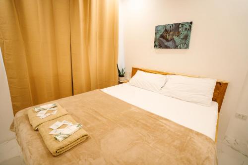 een slaapkamer met een bed met twee handdoeken erop bij MGM tourist Inn in Tagbilaran-stad
