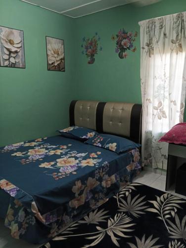 a bedroom with a bed with a blanket on it at Homestay MMr in Temerloh