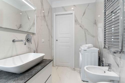a white bathroom with a sink and a toilet at MI Michetti 20 in Milan