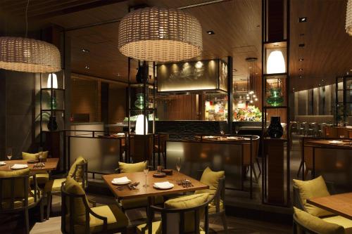 a restaurant with tables and chairs and chandeliers at Grand Hyatt Fukuoka in Fukuoka