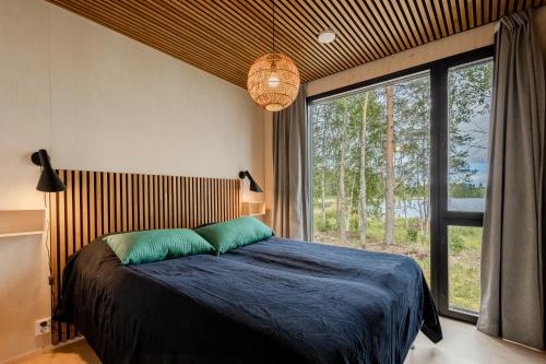 une chambre avec un lit et une grande fenêtre dans l'établissement Villa Lehtoniemi, à Vaala
