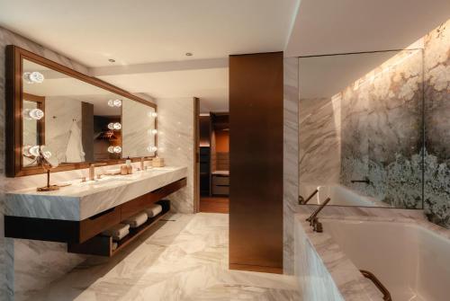 a bathroom with a tub and a sink and a mirror at Grand Hyatt Singapore in Singapore