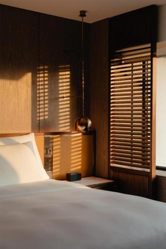 a bedroom with a bed and a window with blinds at Grand Hyatt Singapore in Singapore