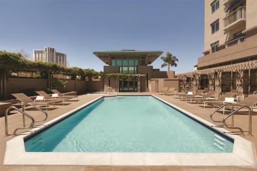 a swimming pool with chairs and a building at Hyatt House Emeryville in Emeryville