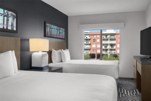 a hotel room with two beds and a window at Hyatt House Emeryville in Emeryville